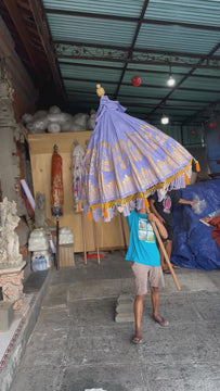 Charlotte Parasol in lavender with hand-painted gold lotus design and vibrant orange fringe, perfect for elegant outdoor spaces.
